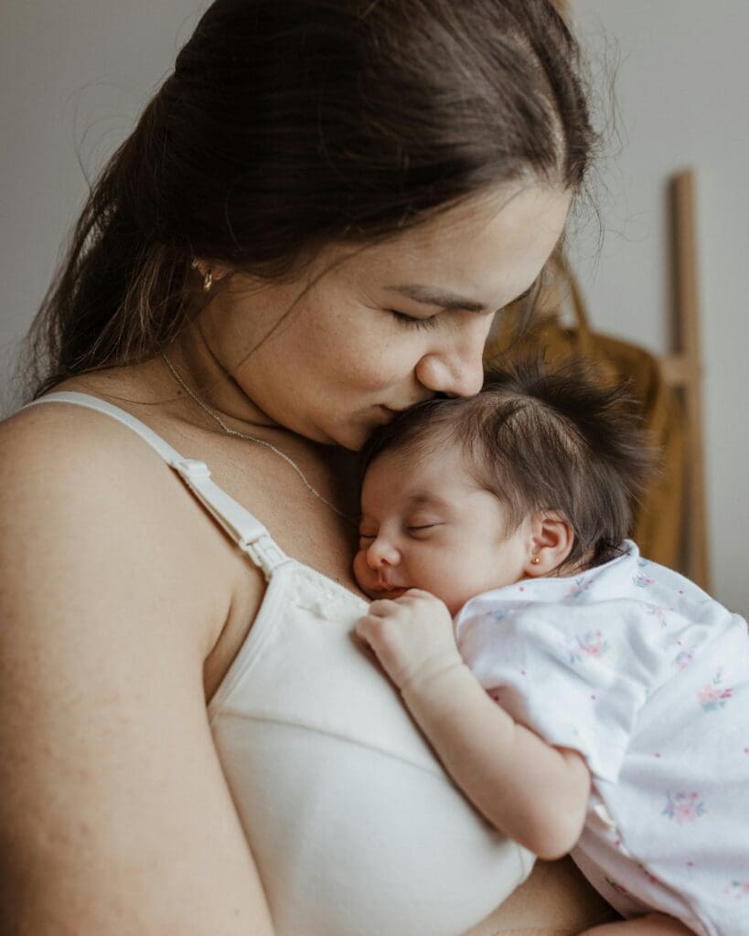 Baby sleeping on mums chest, both mum and baby happy and content