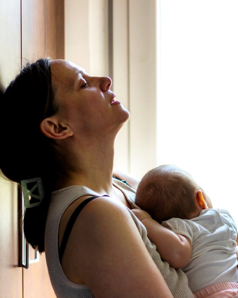 overwhelmed mum holding newborn baby