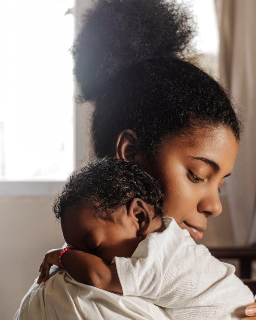 Mum holding her sleeping newborn baby