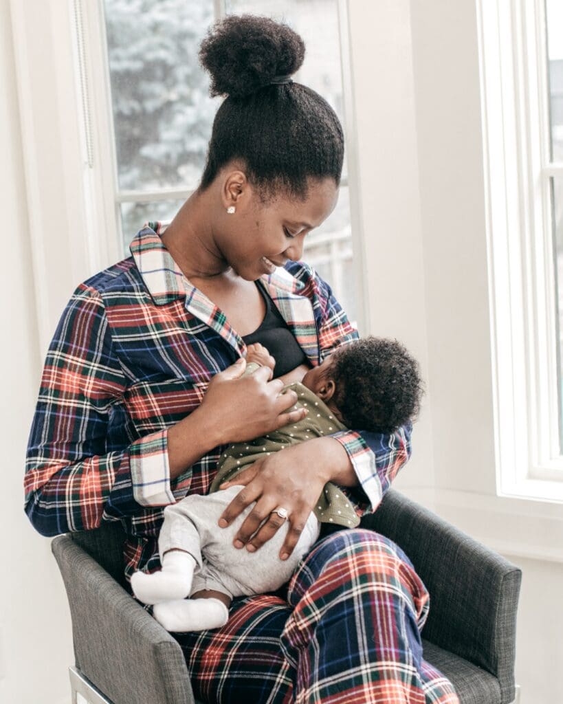 Baby latched at the breast in a cross body, relaxed position, pain free, mum and baby happy